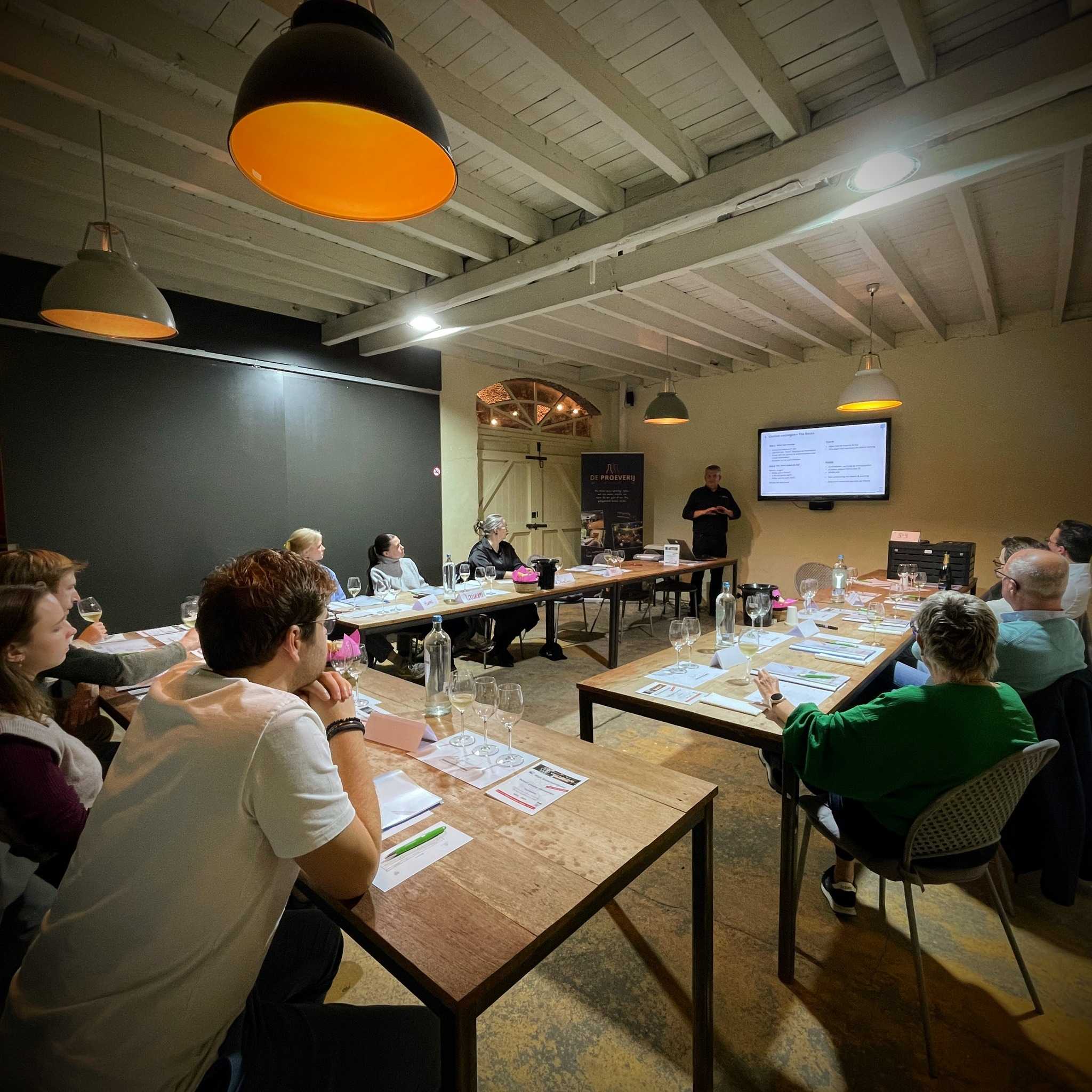 Deelnemers volgen de wijncursus Word Wijnmondig in de zaal van De Proeverij